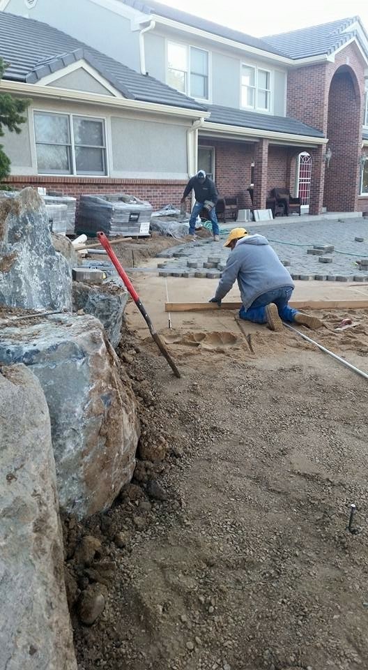Weston team members installing paver patio showcasing construction capabilities